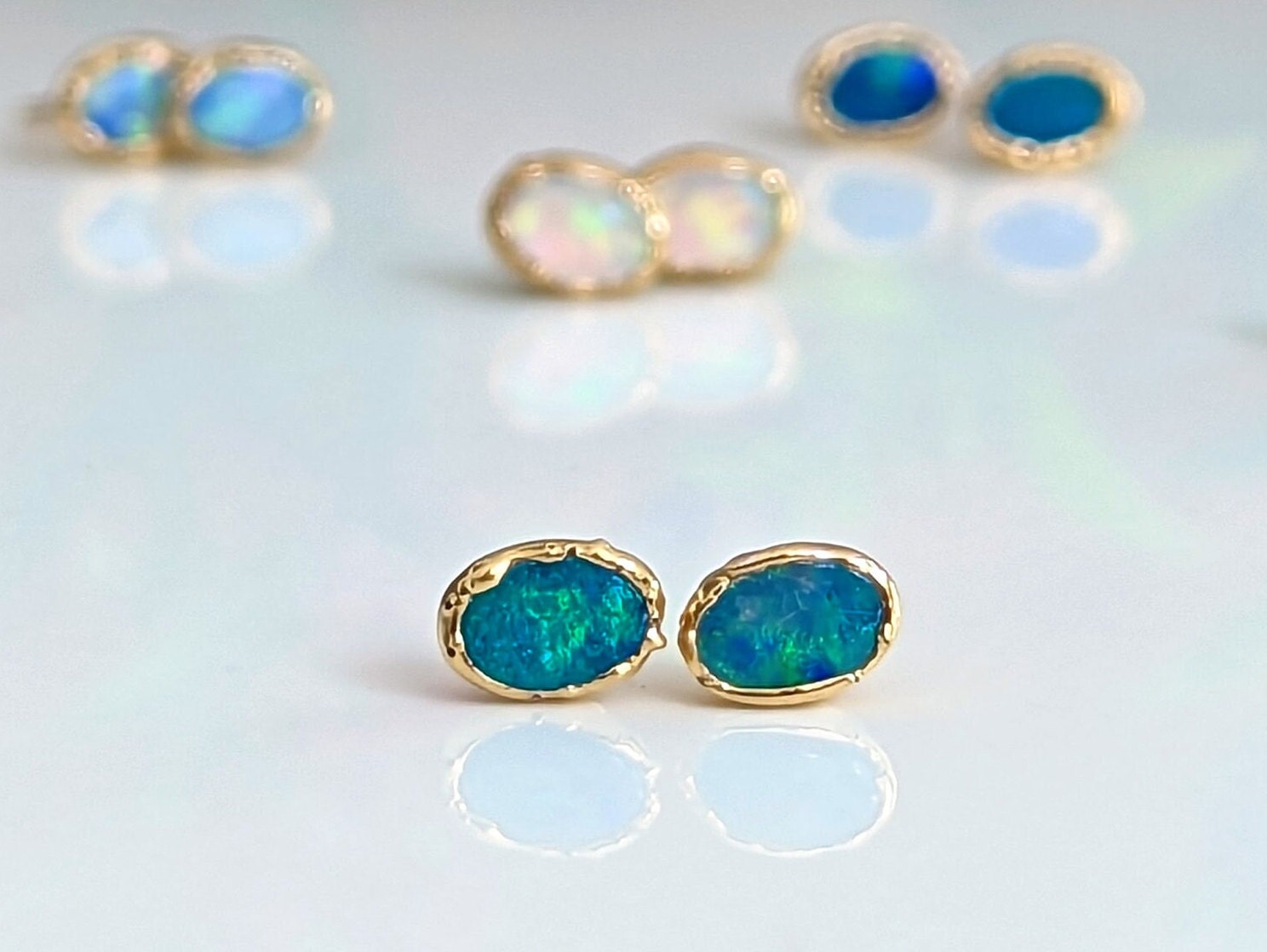 Blue Australian Opal stud earrings in 18k gold, showcasing elegance and handcrafted beauty, perfect for gifts.