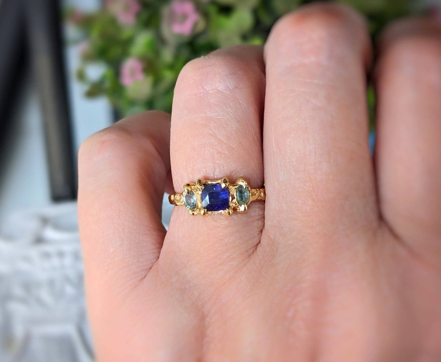 Elegant Blue Sapphire and Tourmaline engagement ring in solid sterling silver on a hand, showcasing its unique design.