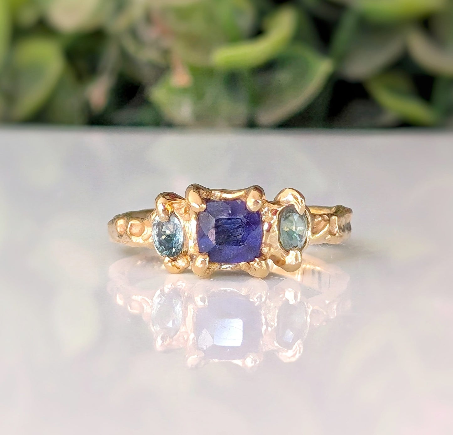 Handcrafted blue sapphire and teal tourmaline engagement ring in solid sterling silver, featuring a textured organic design.