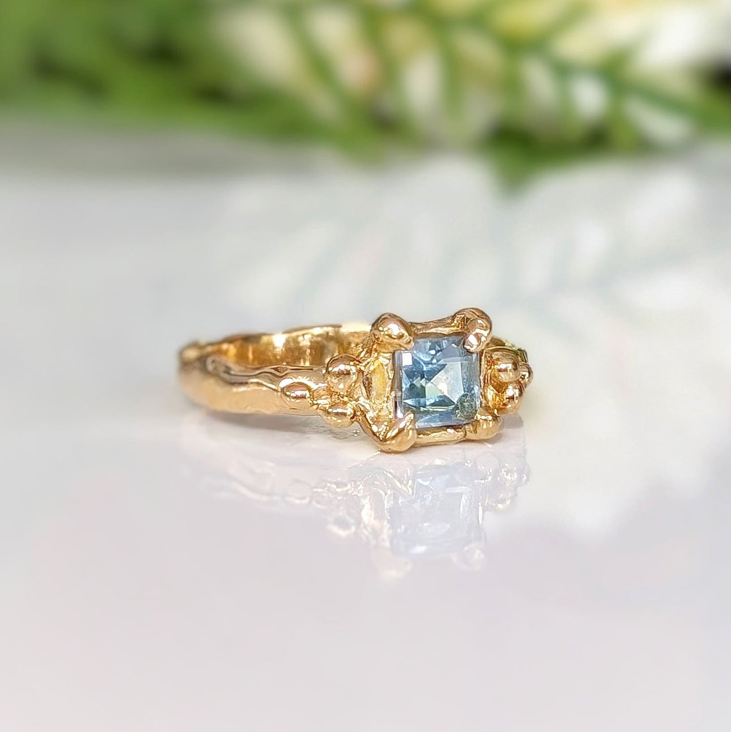 Handcrafted solid 14k gold engagement ring featuring a London Blue Topaz in an organic textured band.