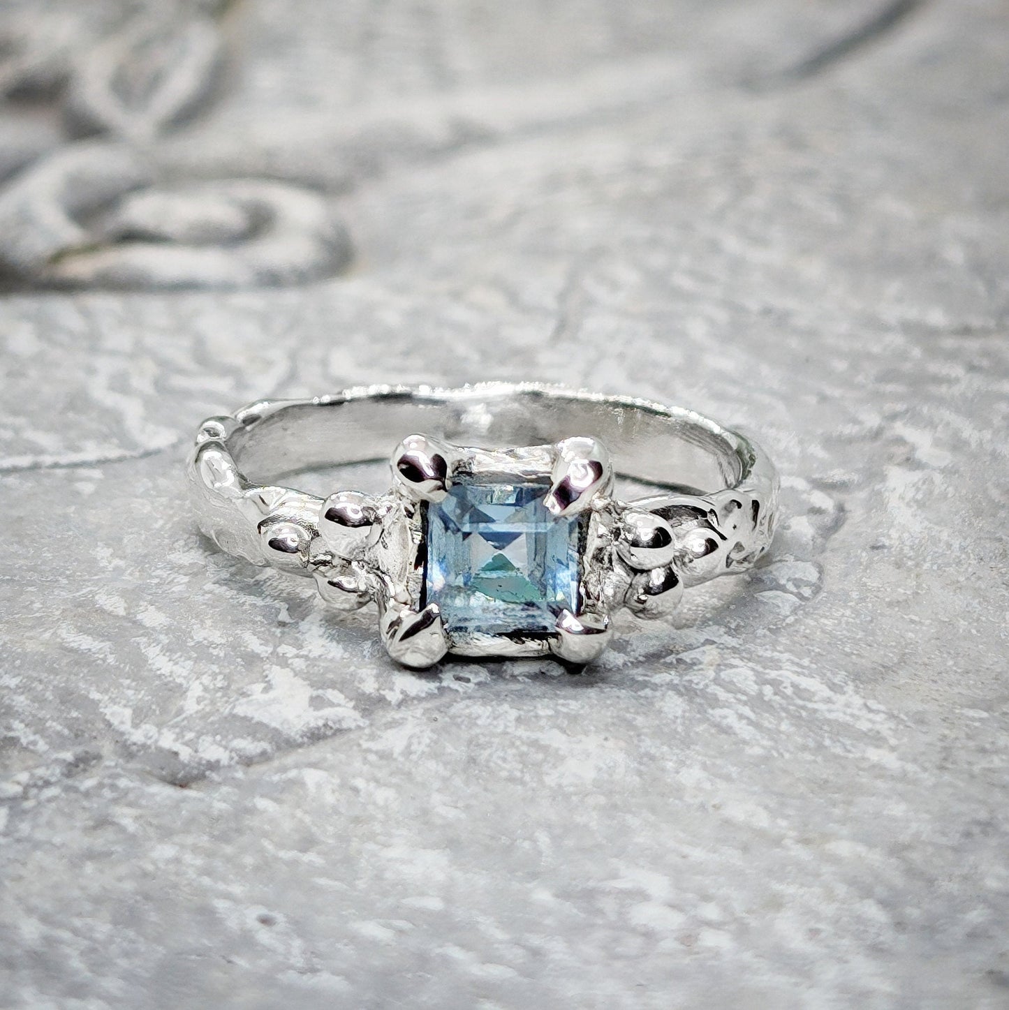 Handcrafted London Blue Topaz engagement ring in solid sterling silver with an organic textured band.