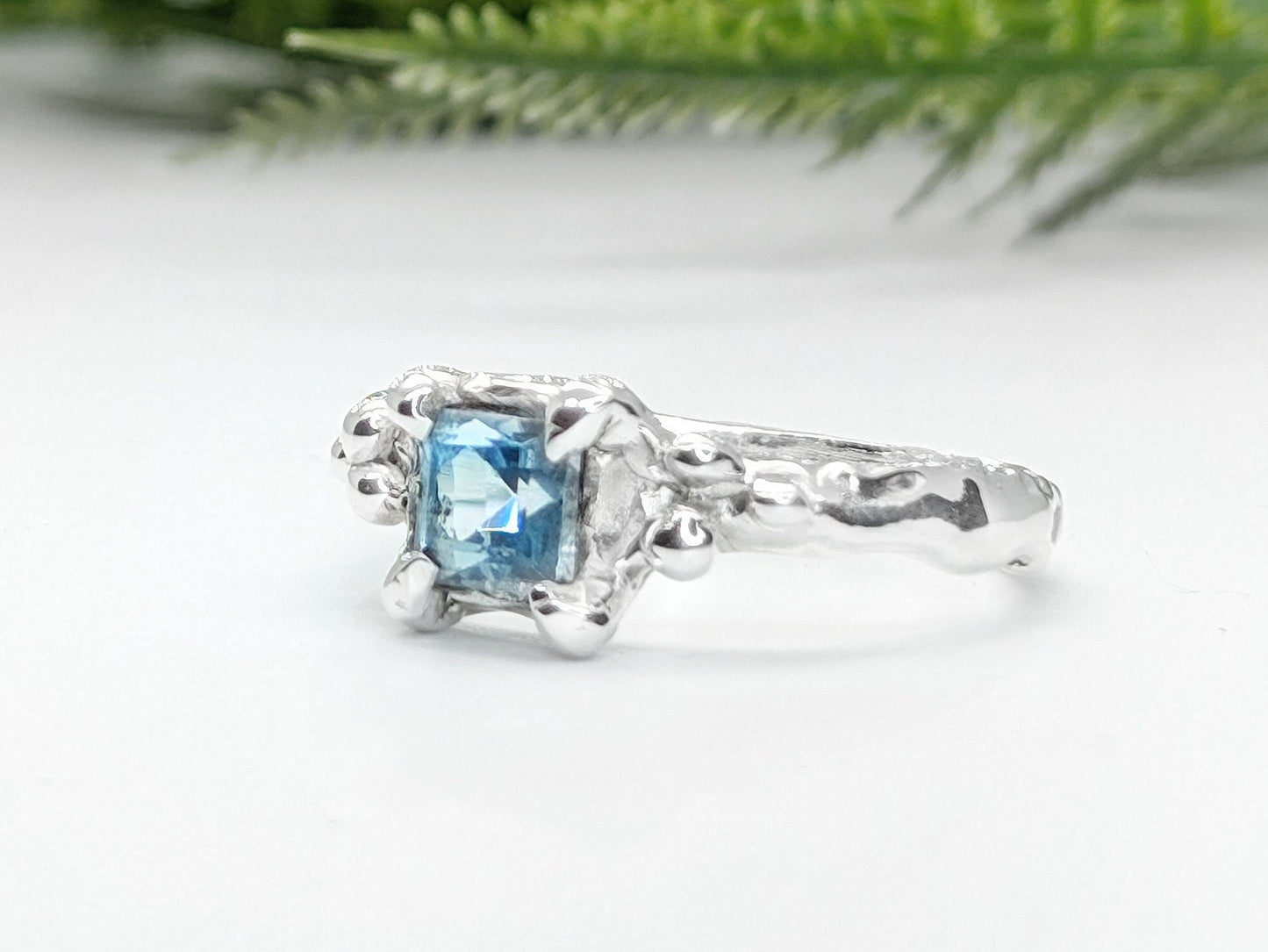Handcrafted London Blue Topaz engagement ring in organic textured sterling silver.