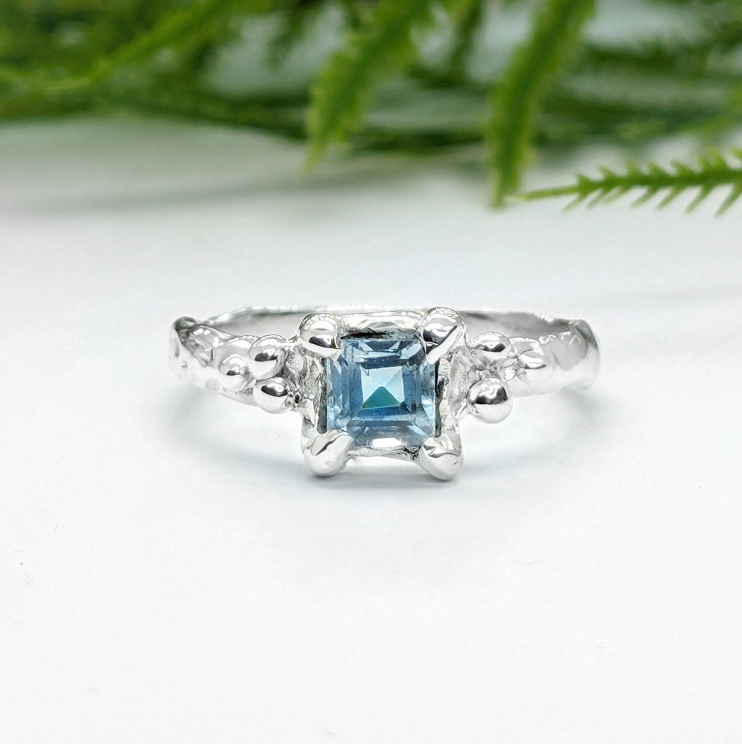 Handcrafted London Blue Topaz engagement ring in solid sterling silver with an organic textured band.