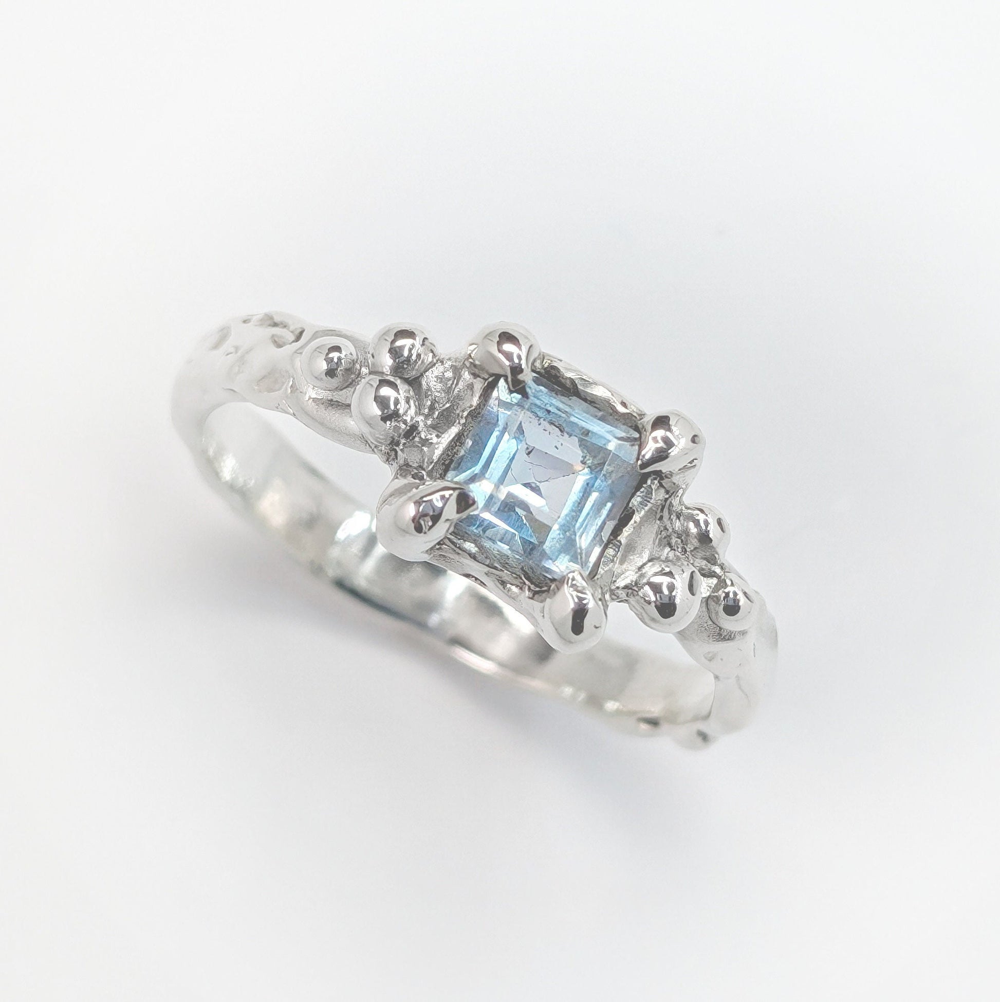 Handcrafted London Blue Topaz engagement ring in textured sterling silver, featuring a stunning blue crystal centerpiece.