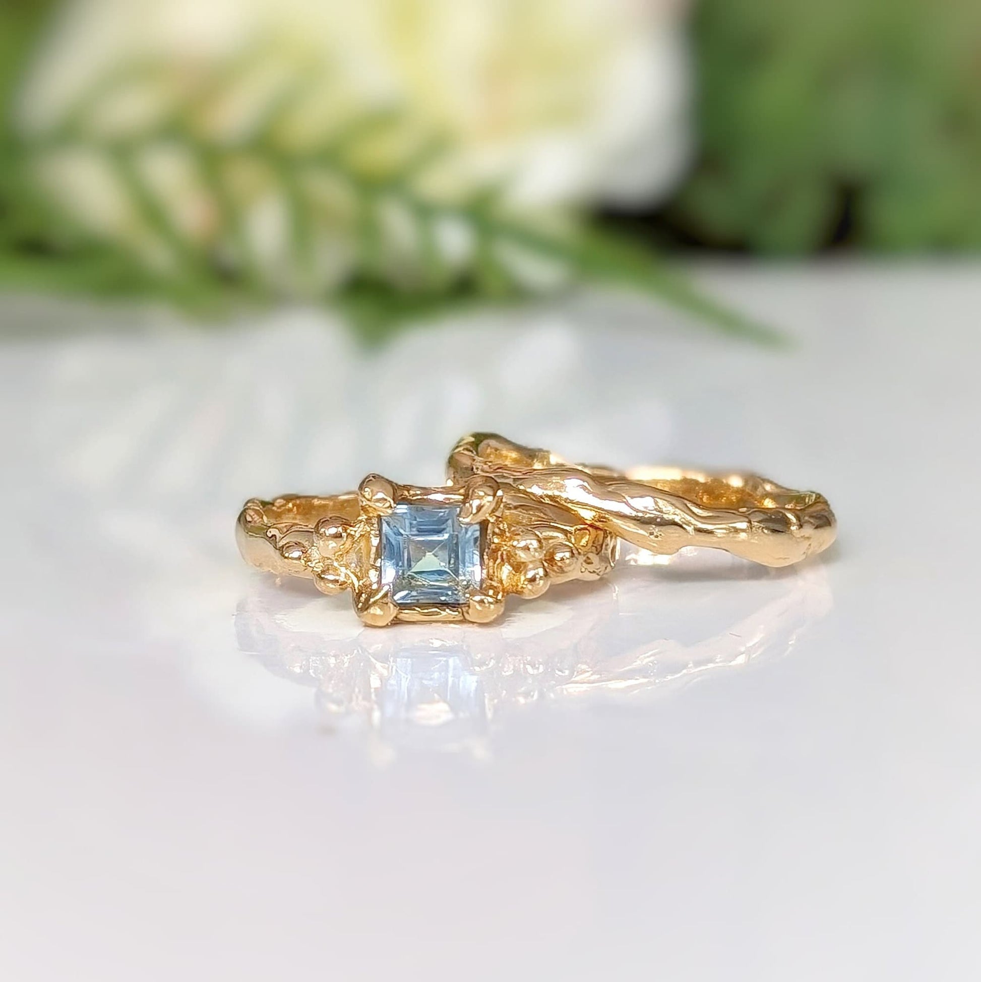 Solid 14k gold London Blue Topaz engagement ring with organic textured band, symbolizing timeless love and individuality.