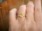 Close-up of a pear shape Citrine ring in solid 14k gold on a hand, showcasing its organic molten band.