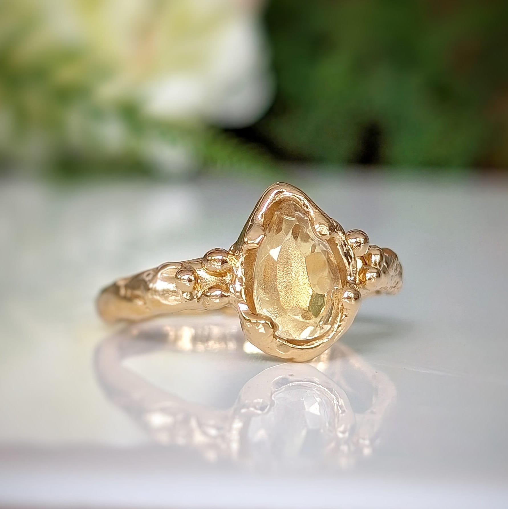 Handcrafted Citrine ring in solid 14k gold with a pear-shaped yellow crystal and an organic molten band.