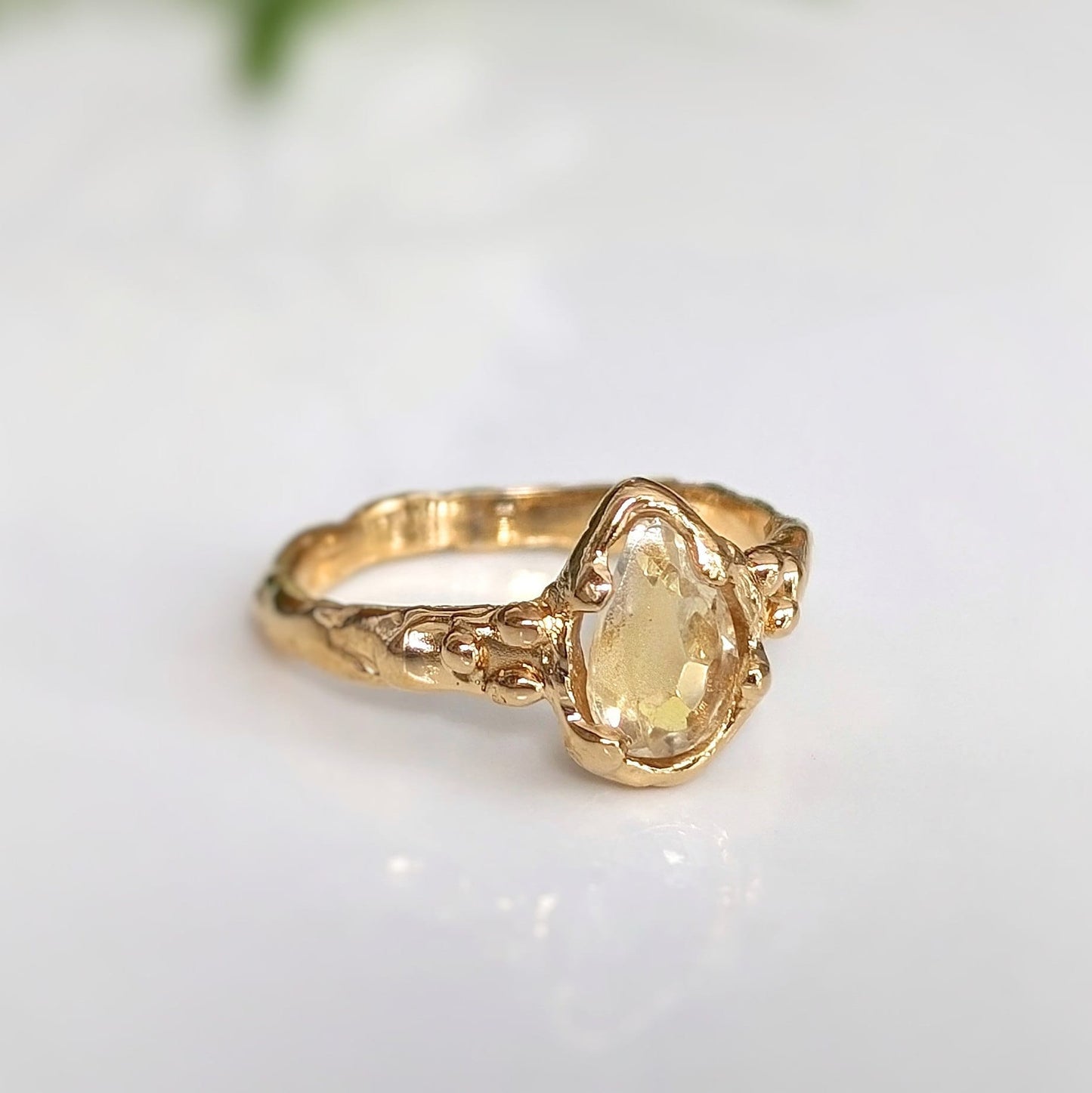 Citrine ring in solid 14k gold with a pear-shaped yellow crystal and textured band, perfect for engagement.