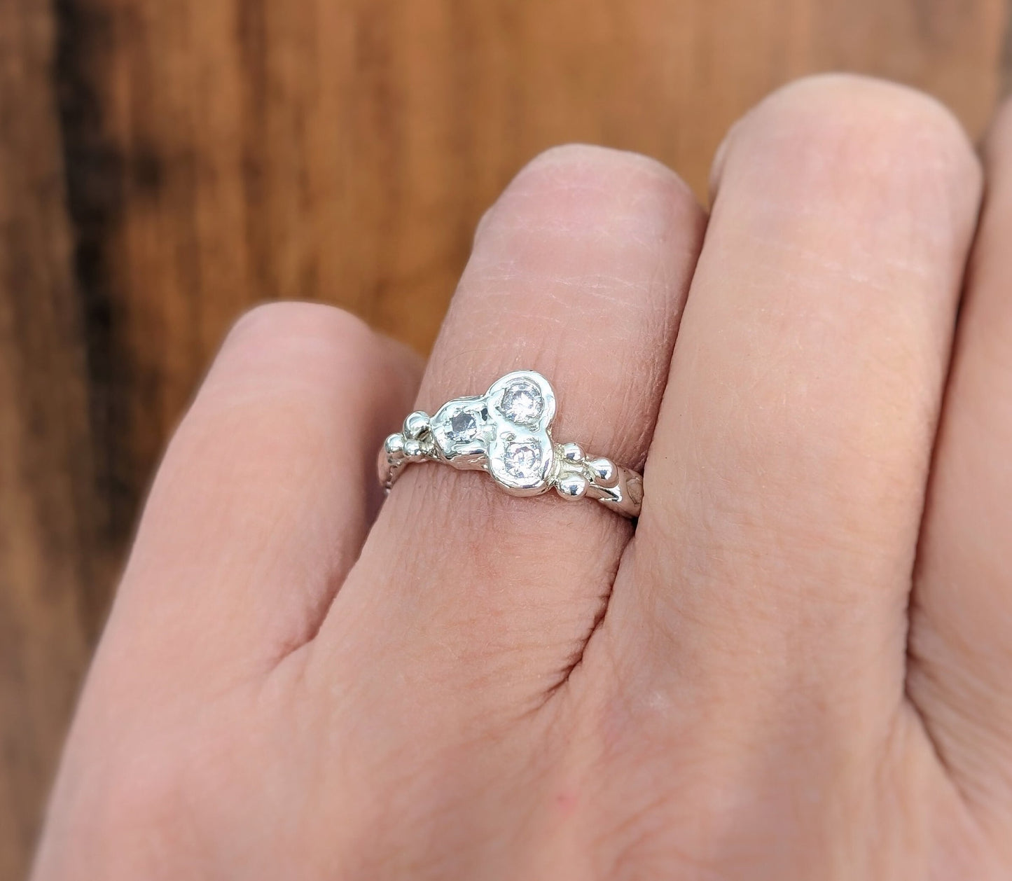 Cubic Zirconia cluster ring in solid 14k gold, showcasing a dazzling trio of stones on a textured band.