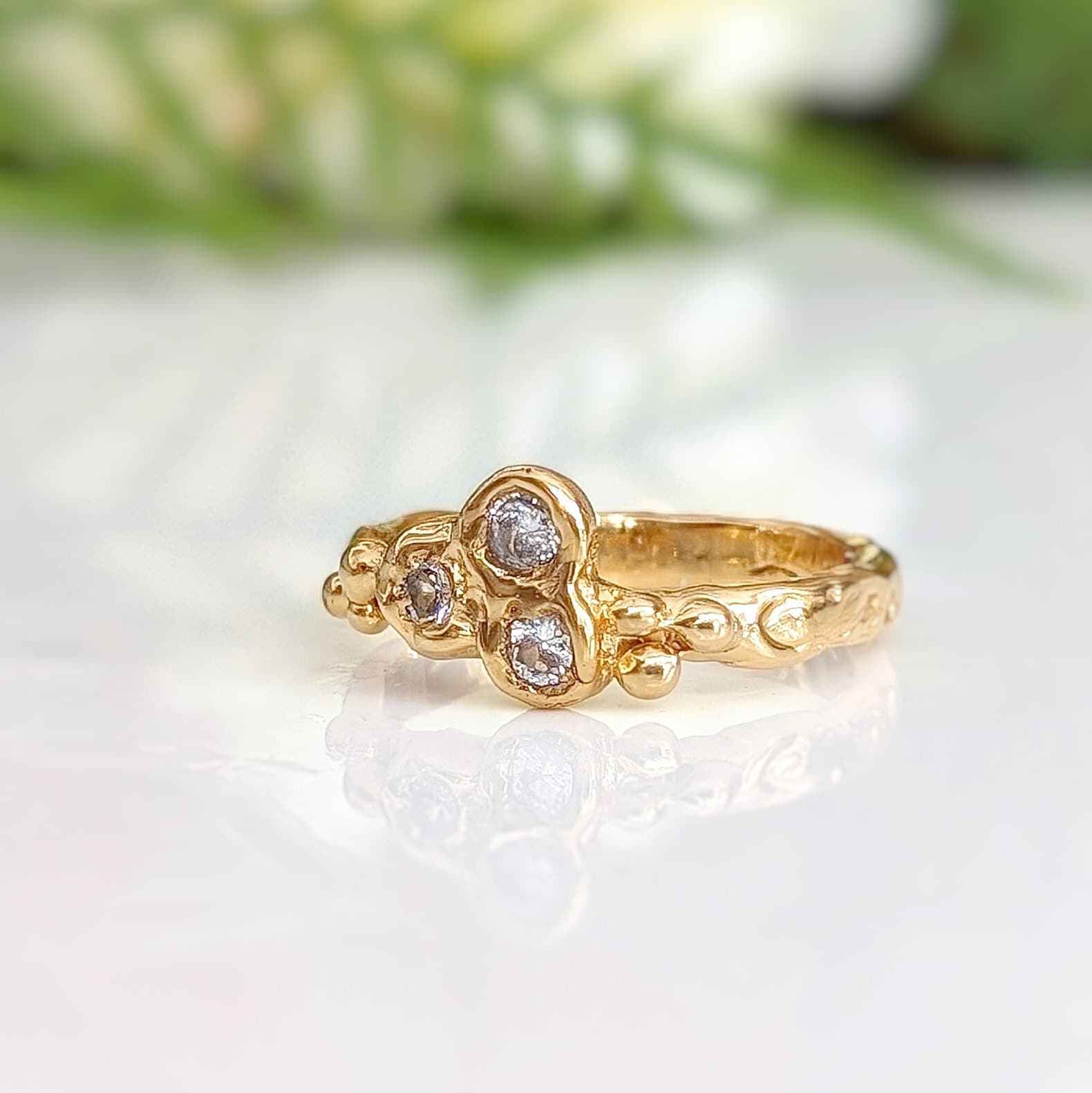 Cubic Zirconia cluster ring in solid 14k gold with organic textured band and sparkling stones.