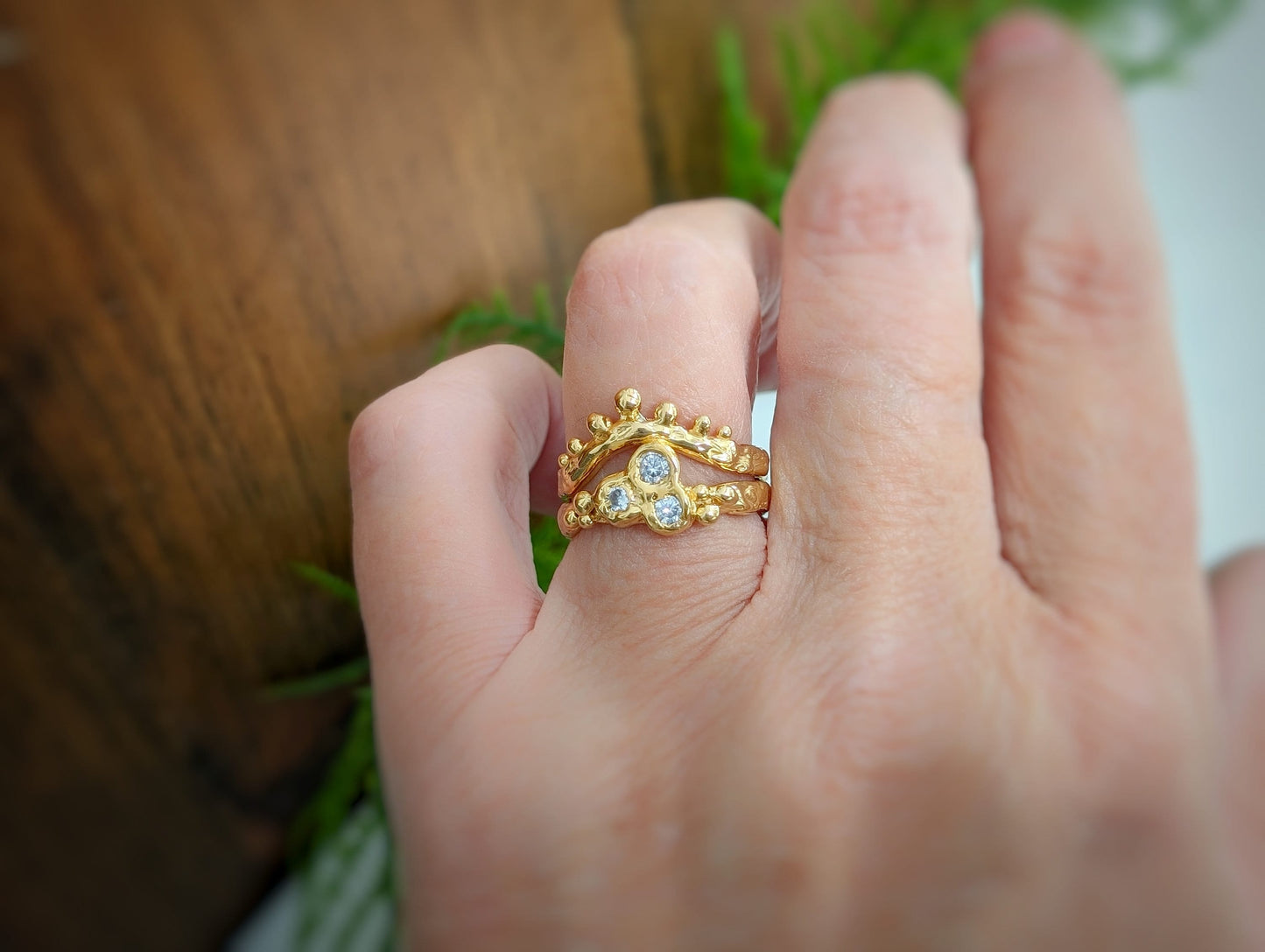 Cubic Zirconia cluster ring in solid 14k gold displayed on a hand, showcasing its organic textured band and sparkling stones.