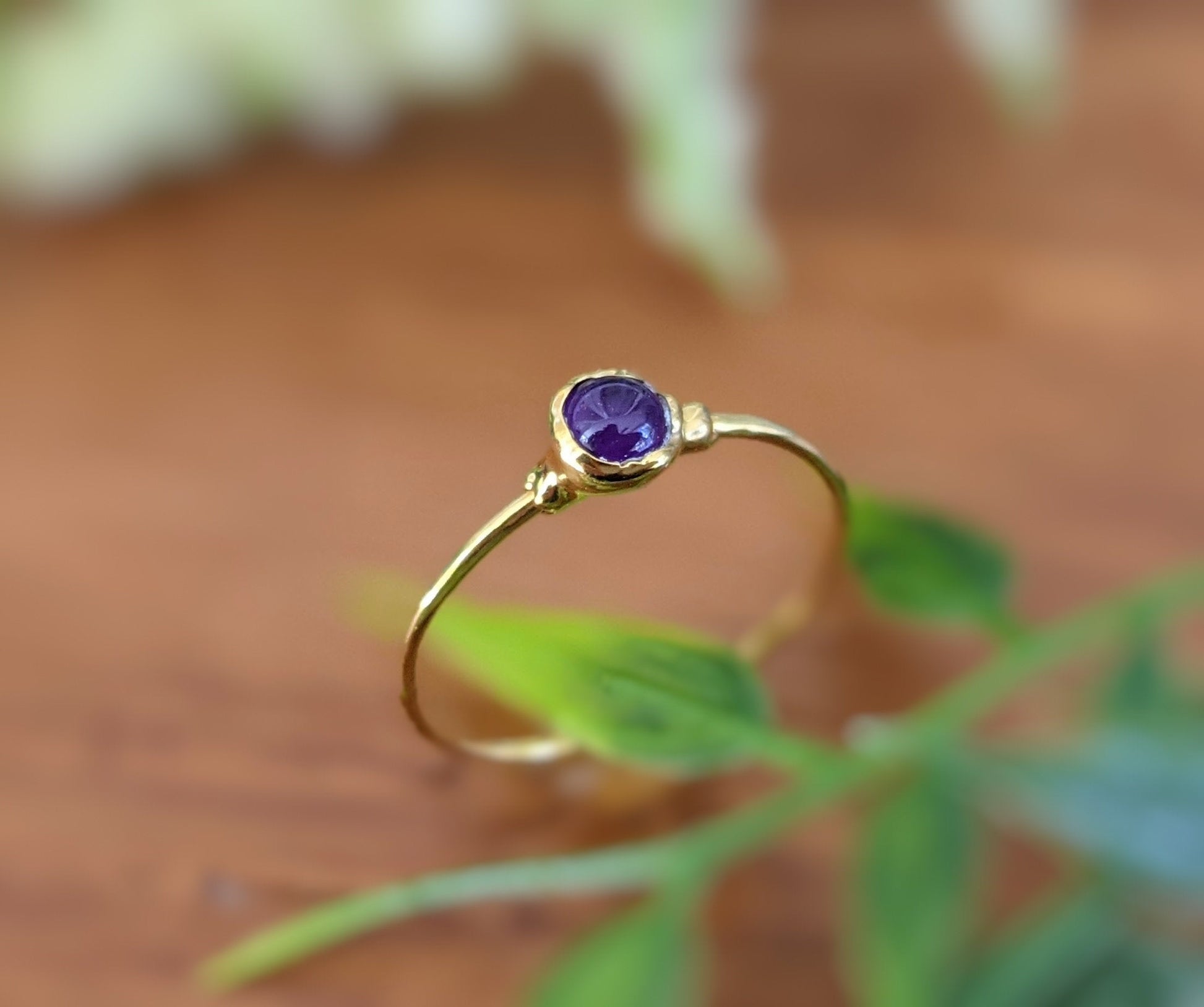 Dainty gold stacking ring featuring a 4mm natural purple Amethyst gemstone, perfect for everyday wear.
