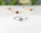 Dainty blue topaz stacking ring on a silver band, perfect for everyday wear and stacking with other rings.