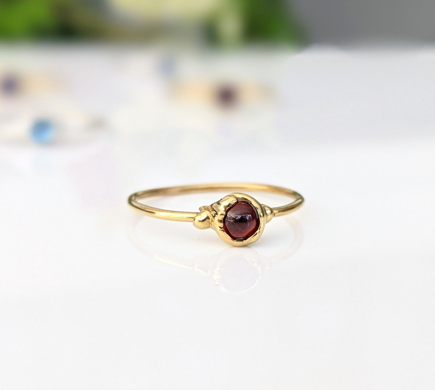 Dainty gold stacking ring featuring a small natural red Garnet gemstone, perfect for everyday wear.