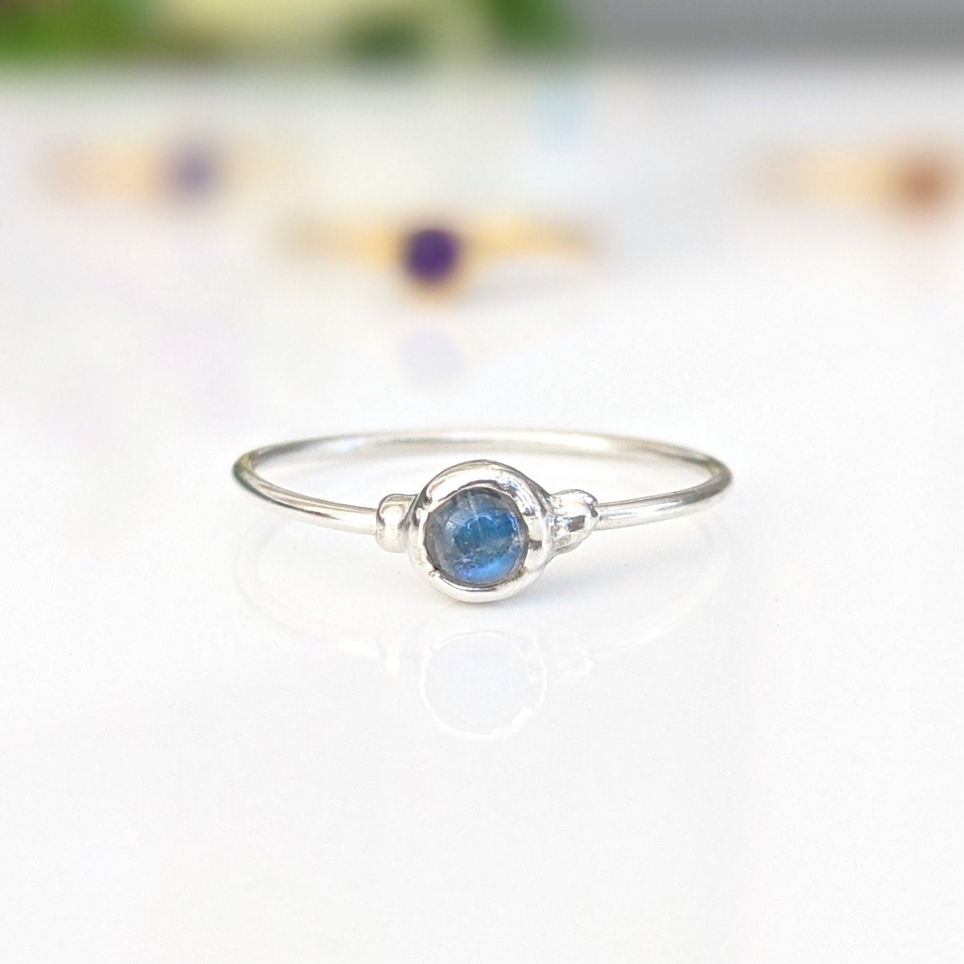 Dainty stackable ring featuring a natural blue gemstone set in a sleek silver band, perfect for minimalist jewelry lovers.
