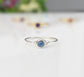 Dainty rainbow Moonstone stacking ring on a plain surface, perfect for minimalistic jewelry lovers.