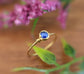 Dainty gold stacking ring featuring a natural blue Sapphire gemstone with floral background.