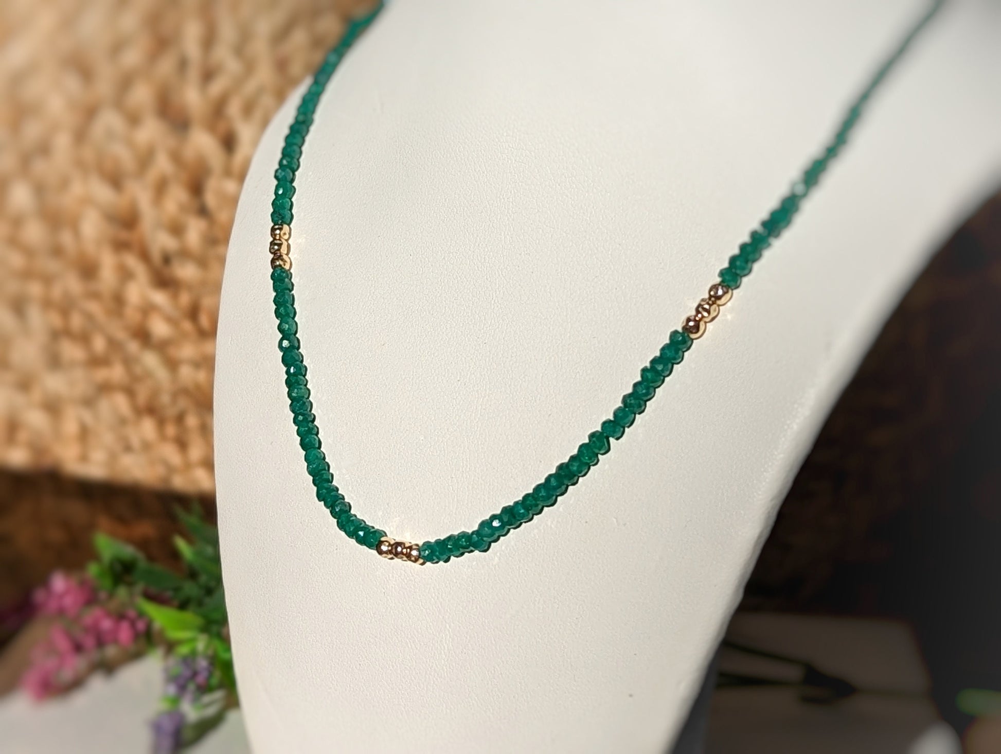 Emerald bead necklace showcasing unique green shades, symbolizing love and friendship, with gold accents.
