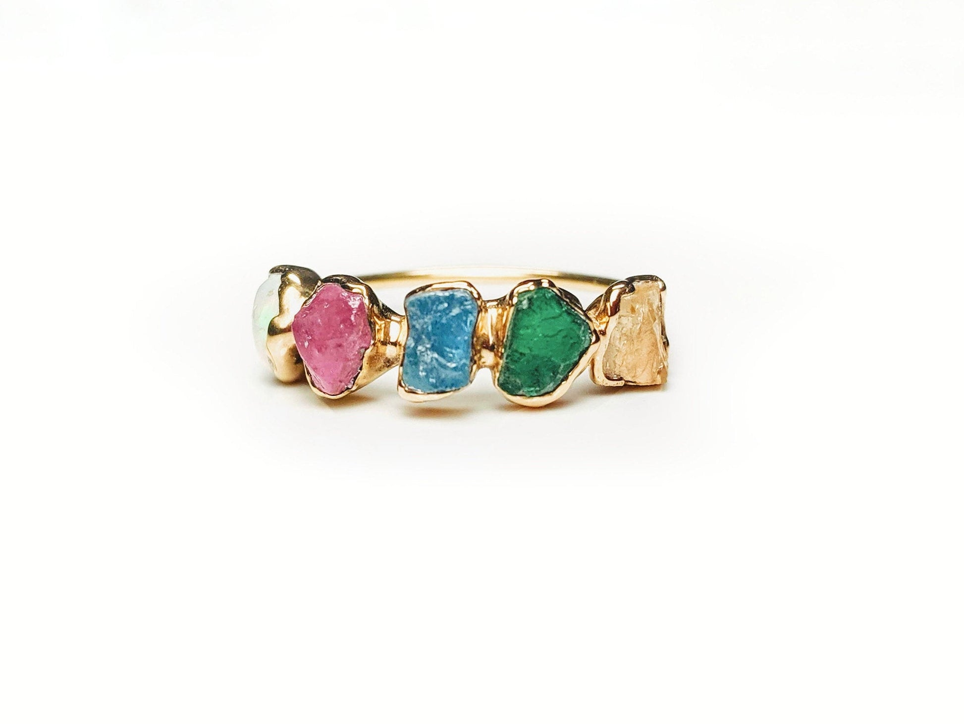 Custom mother's ring with raw gemstones in gold, representing family birthstones for a unique heirloom gift.