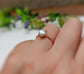 Handcrafted freshwater Keshi pearl ring in 18k gold on a hand, surrounded by greenery, showcasing elegance.