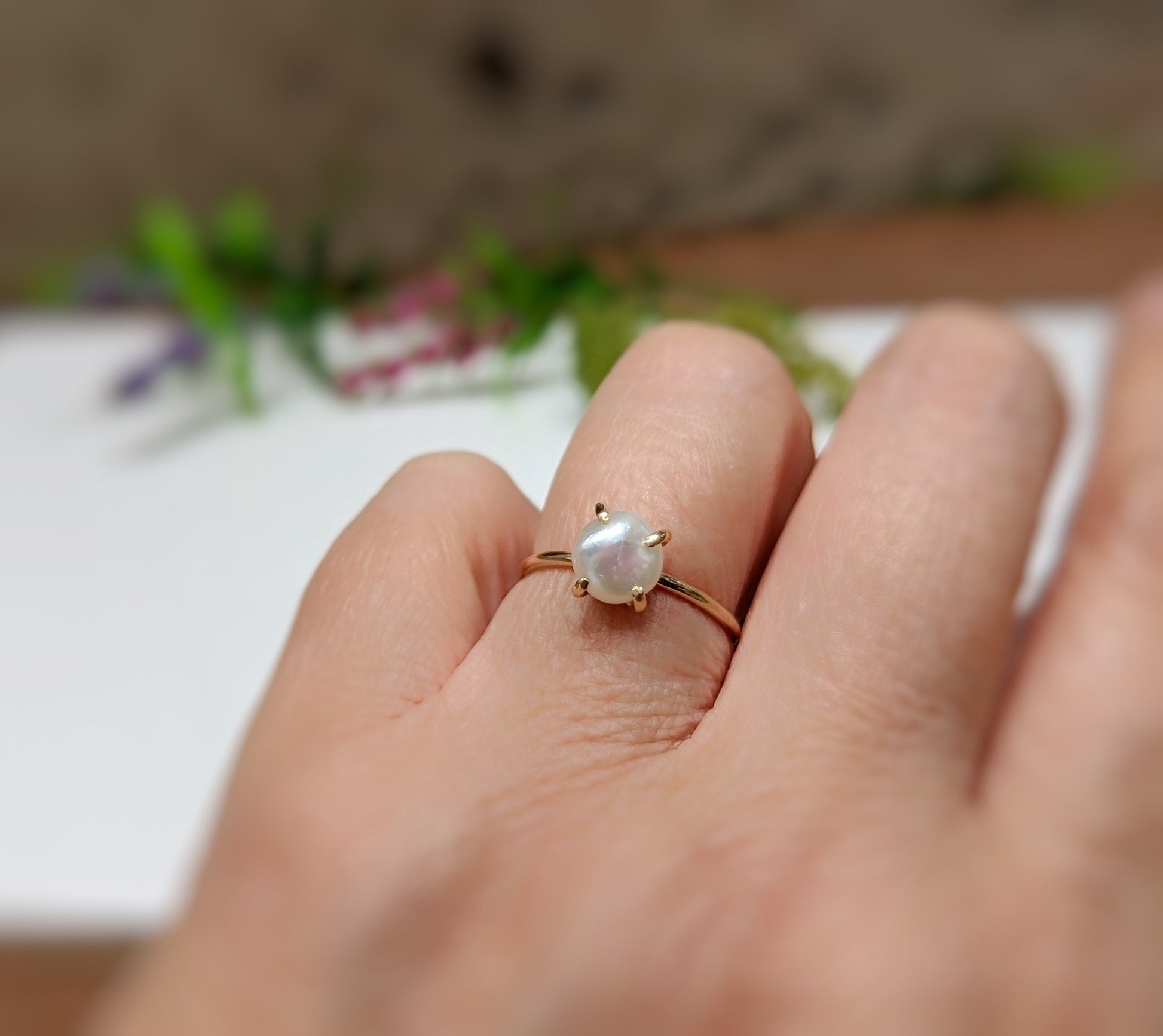 Handcrafted freshwater Keshi pearl ring set in 18k gold displayed on a hand, symbolizing love and friendship.