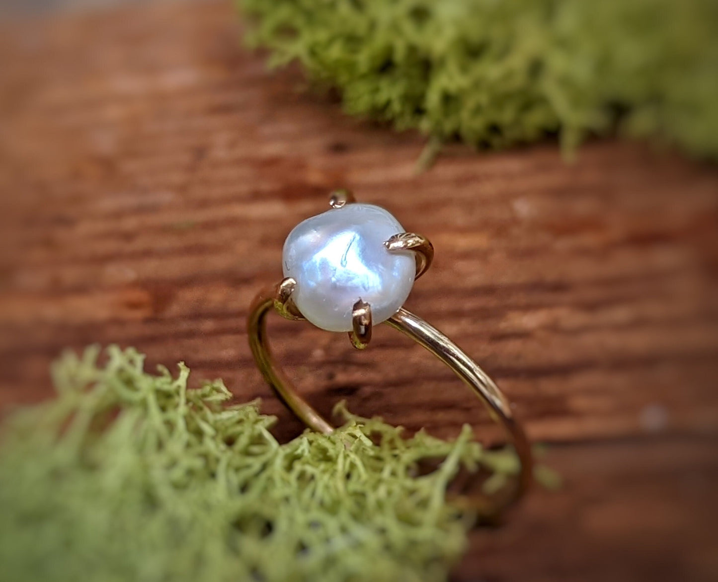 Freshwater Keshi pearl ring in 18k gold setting, featuring a stunning, handcrafted design on a wooden surface.