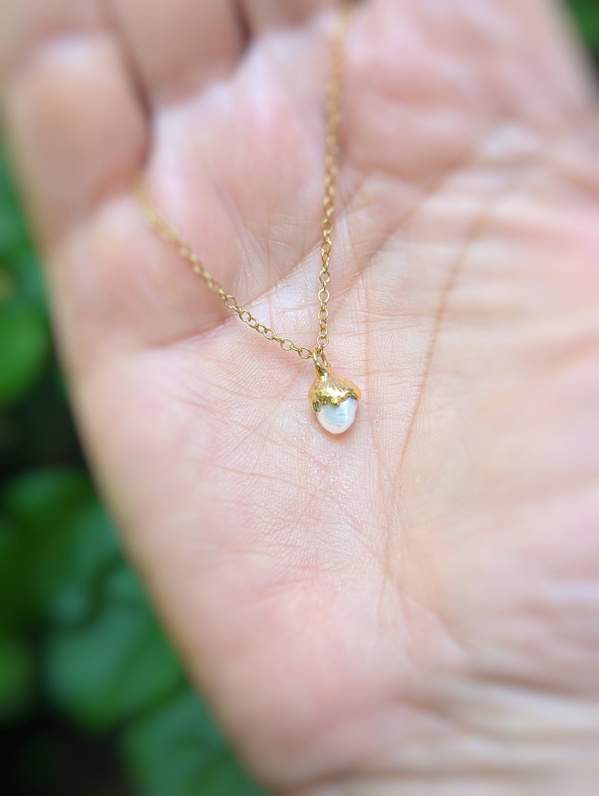 Dainty Freshwater Keshi Pearl necklace on a hand, 18k gold plating, elegant gift for special occasions.