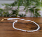 Delicate freshwater pearl necklace on wooden surface, showcasing elegance and timeless beauty for special occasions.