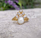 Freshwater pearl and raw diamond chevron wedding ring set in solid 14k gold, showcasing rustic elegance.