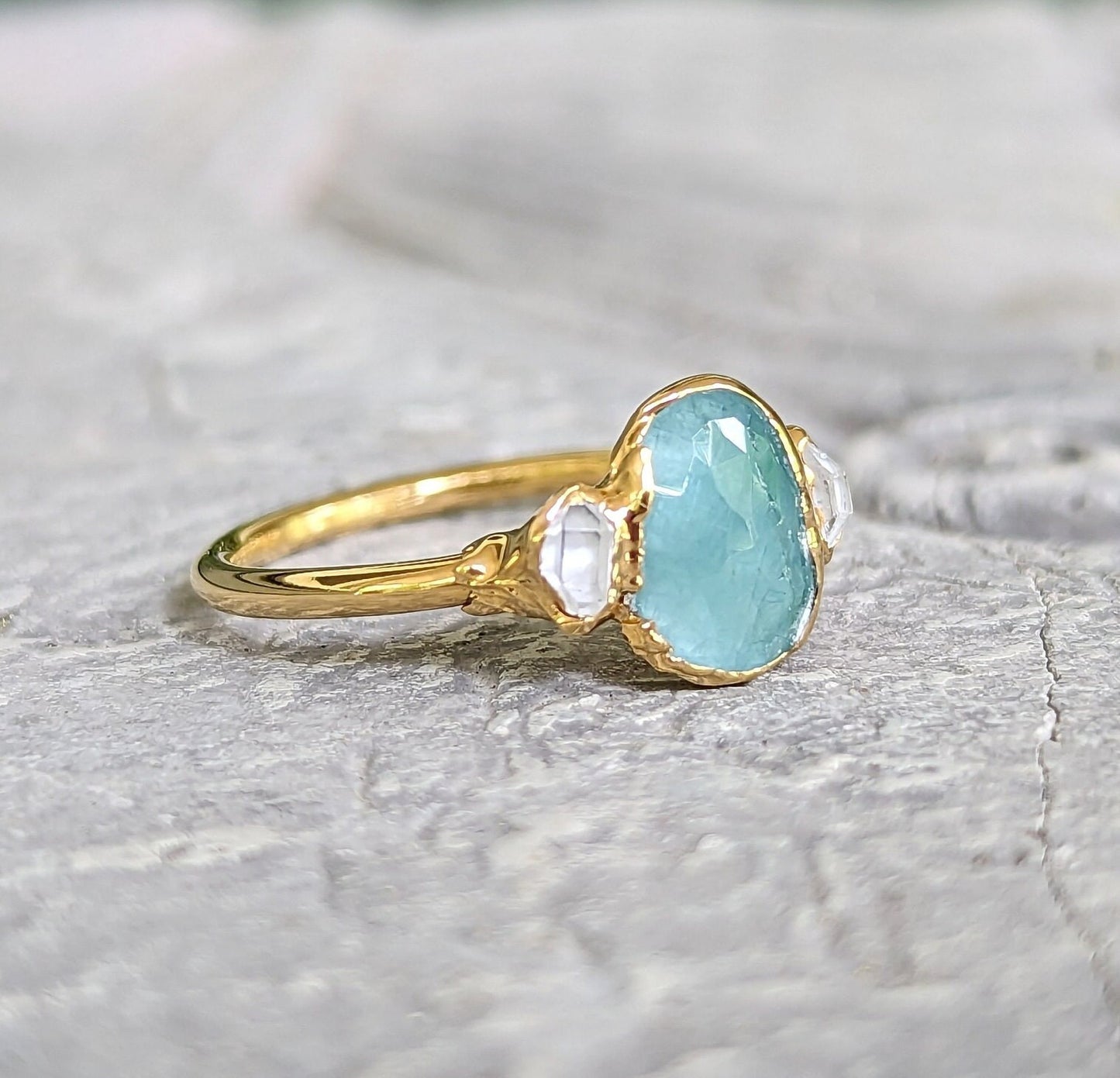 Aqua blue Grandidierite ring with Herkimer diamonds, set in 18k gold, showcasing unique craftsmanship.