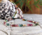 Handcrafted Multi Tourmaline bead necklace featuring vibrant colors and gold accents on a natural background.