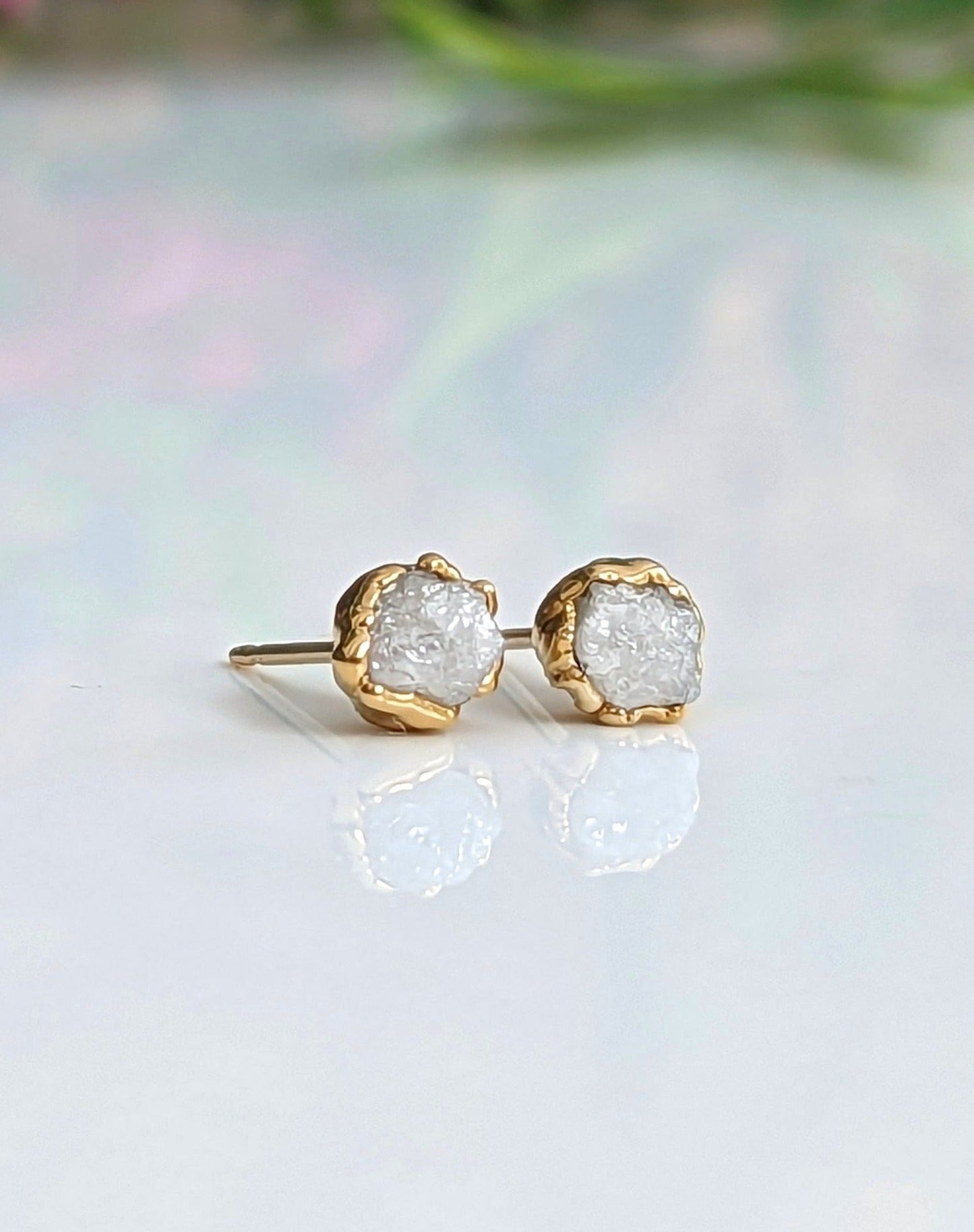 Ethically sourced raw diamond stud earrings with gold settings, showcasing natural uncut beauty and timeless elegance.