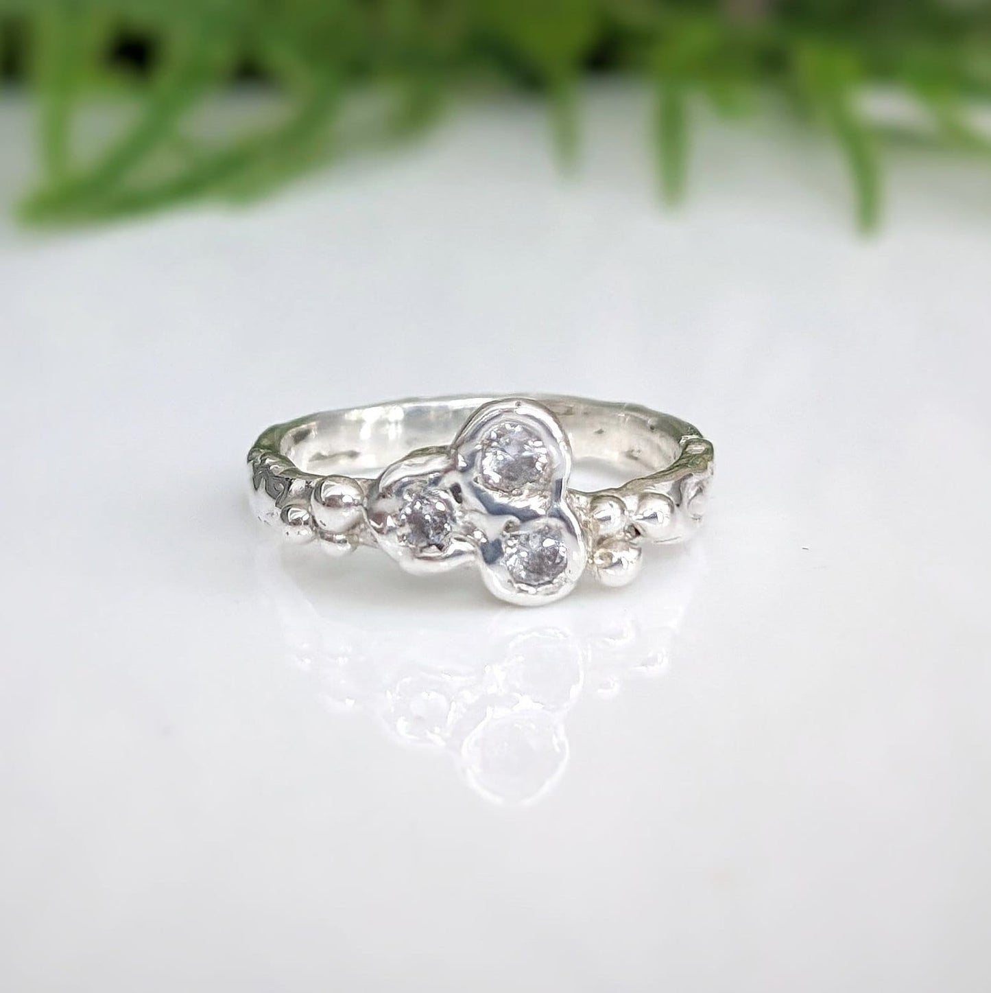 Handcrafted sterling silver CZ cluster ring with three cubic zirconia stones, showcasing elegance and brilliance.