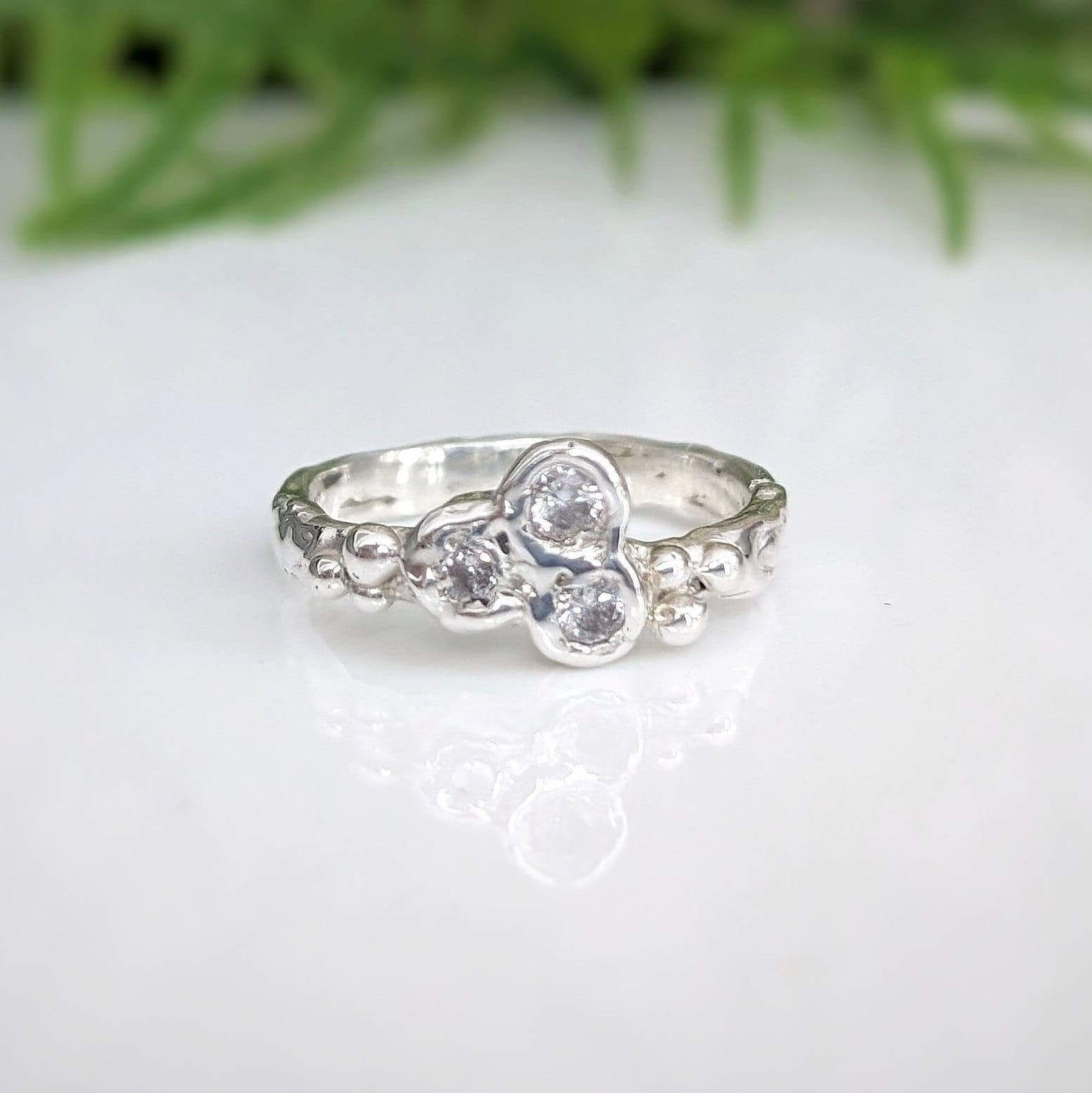 Handcrafted sterling silver CZ cluster ring with three cubic zirconia stones, showcasing elegance and brilliance.