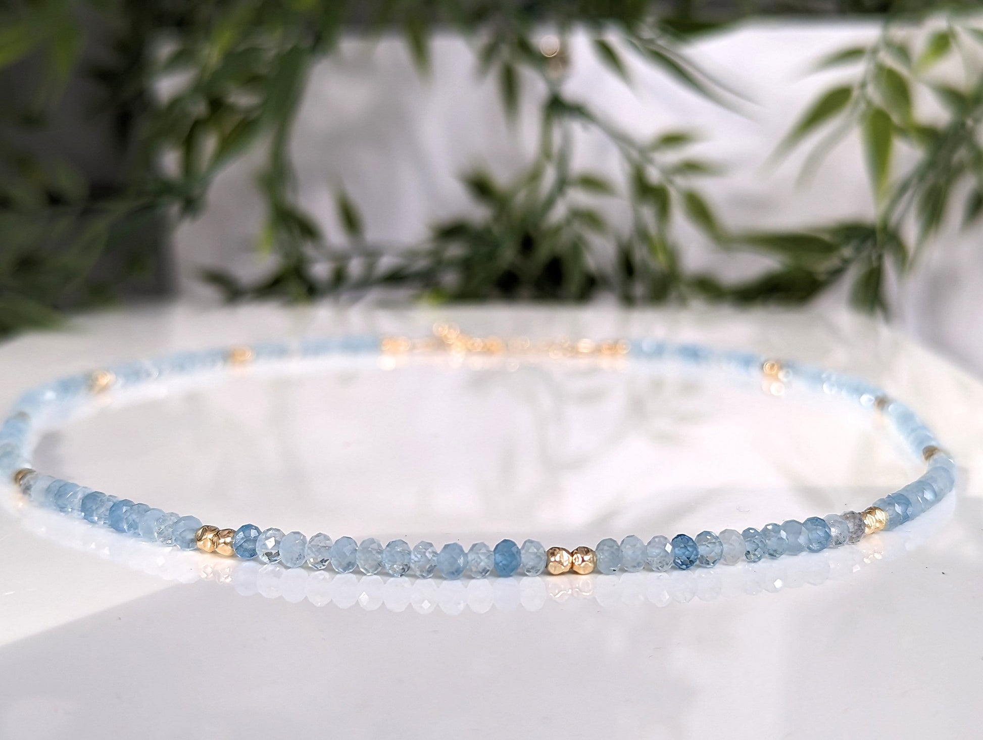 Handmade aquamarine bead necklace with gold accents, showcasing a serene blue hue and natural gemstone beauty.