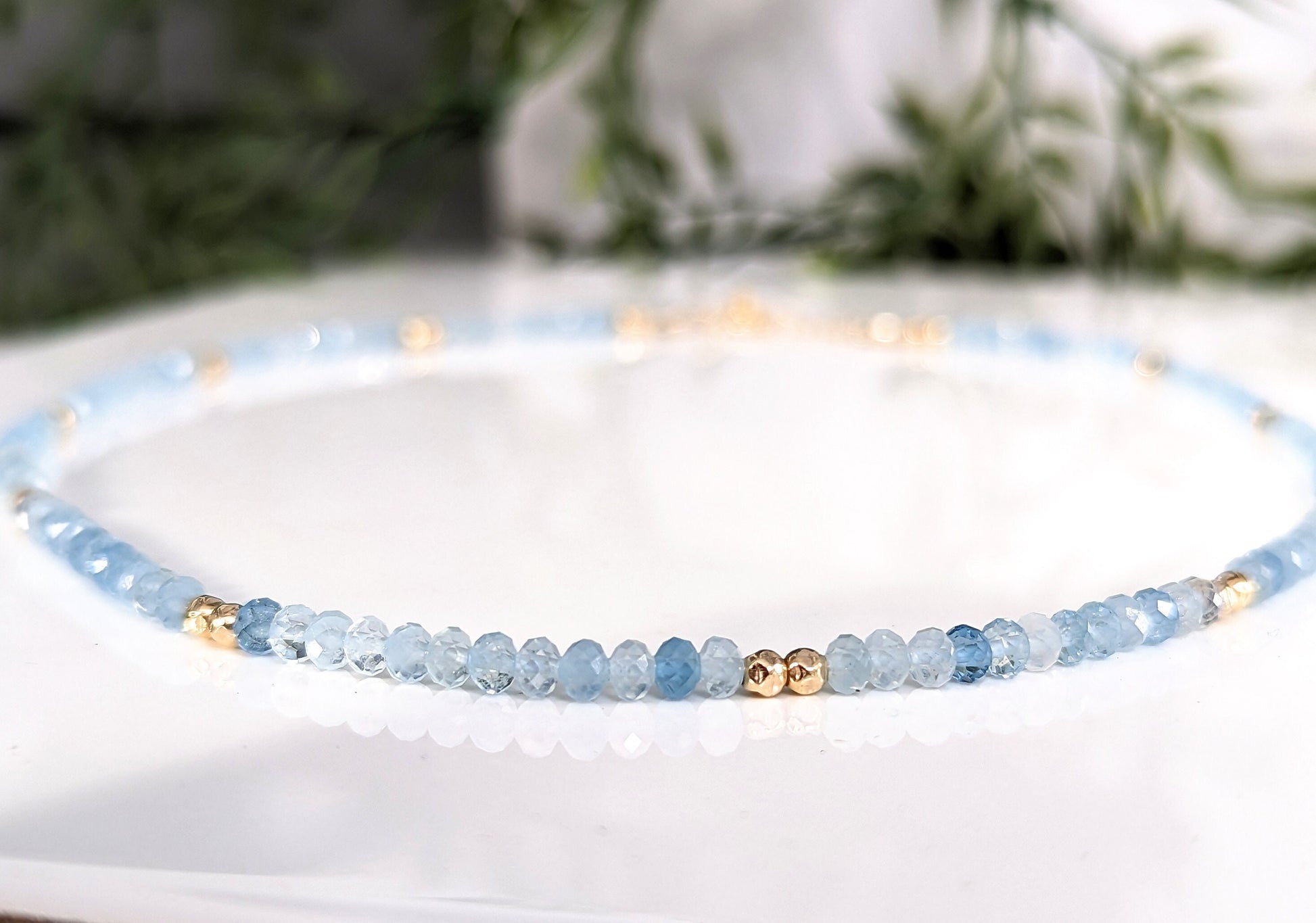 Handmade aquamarine bead necklace featuring soft blue gemstones and gold accents, symbolizing calmness and loyalty.