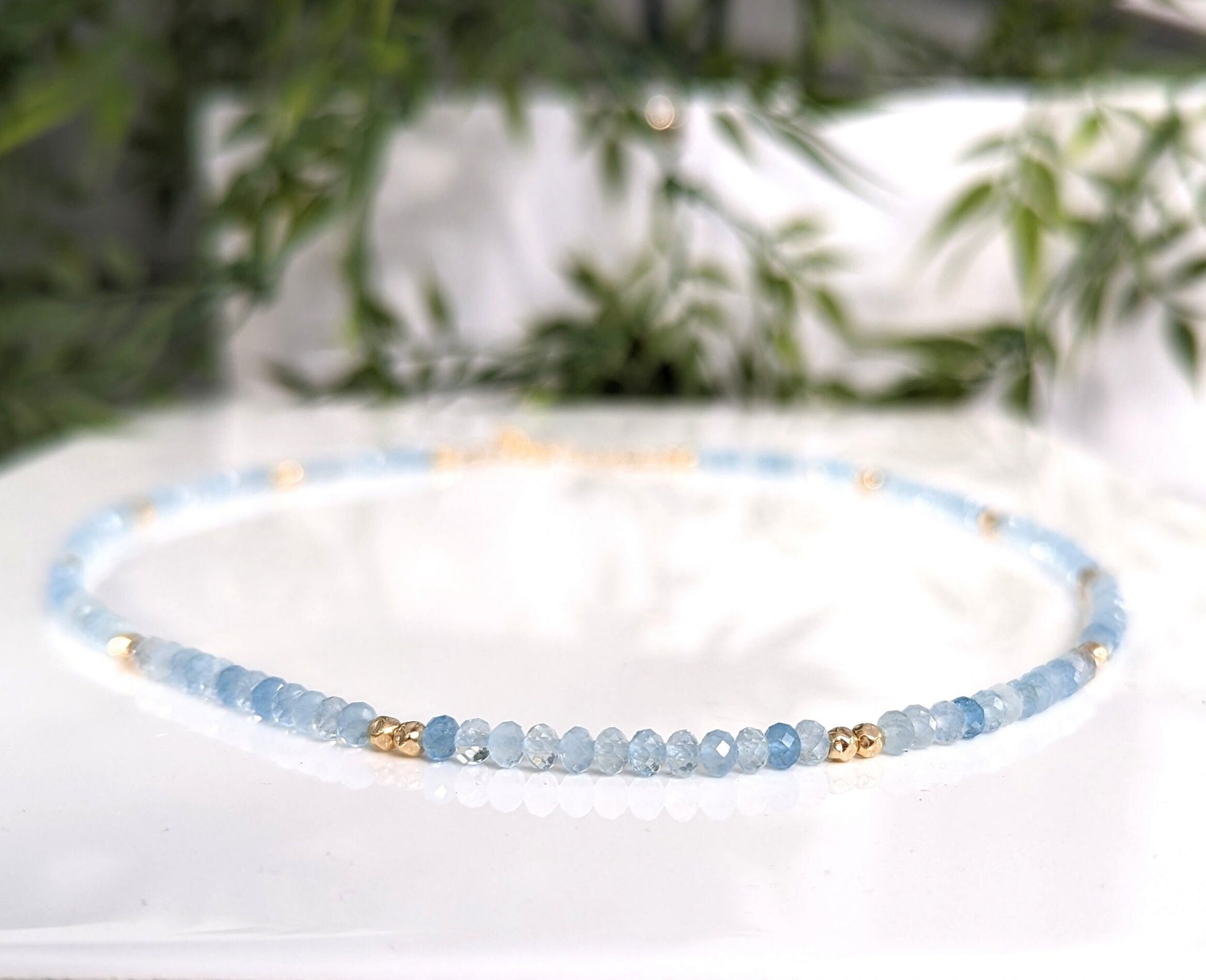Handmade aquamarine bead necklace with gold accents, symbolizing calmness and loyalty, perfect for gifts.