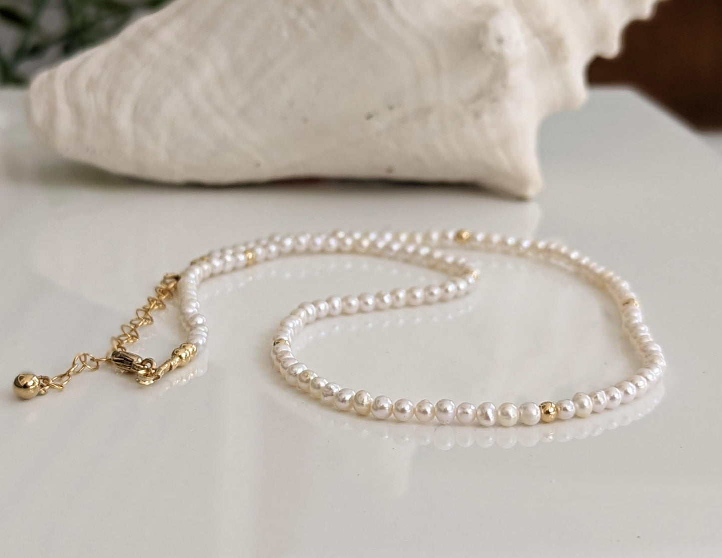 Delicate freshwater pearl necklace with gold accents, perfect for weddings and Mother's Day gifts.