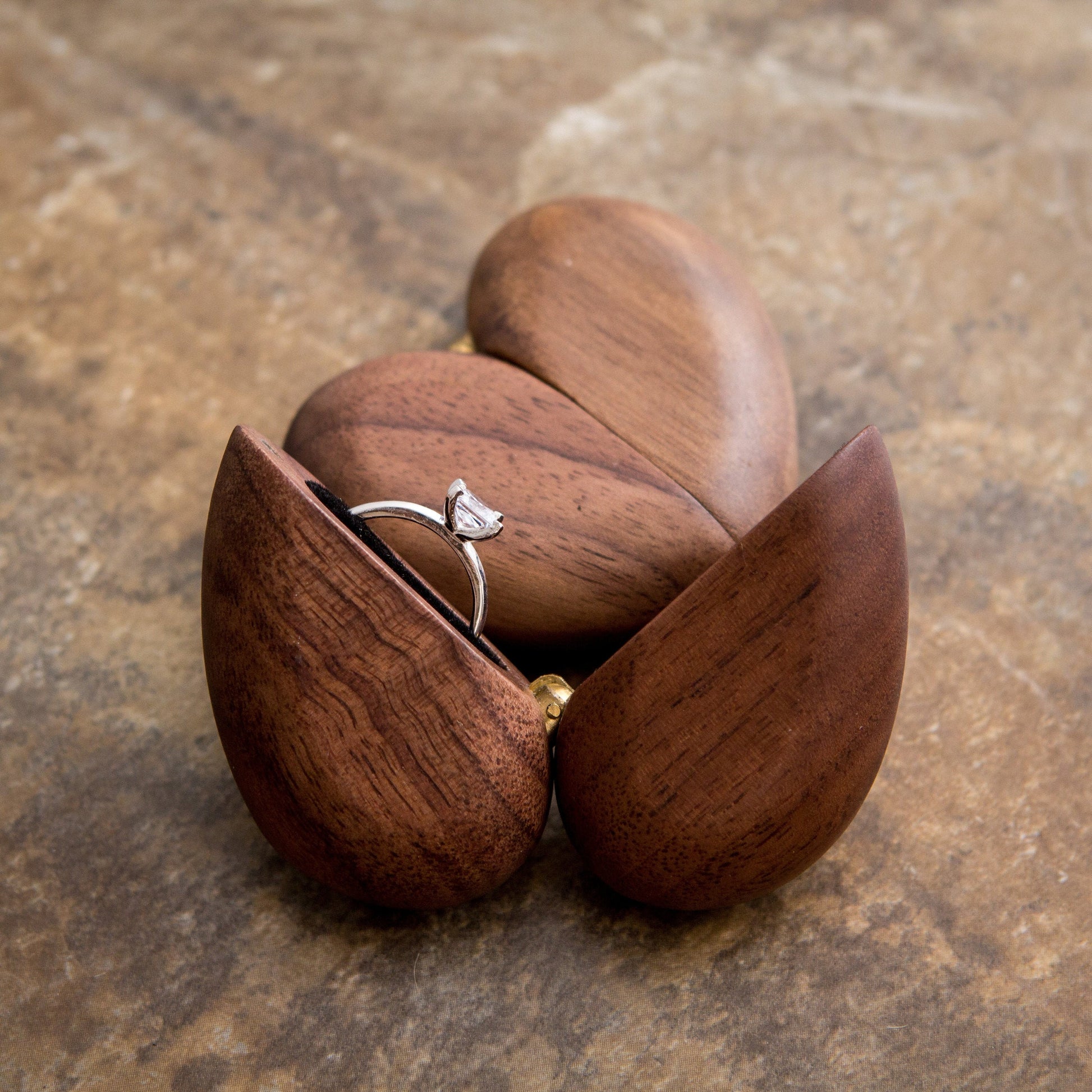 Wooden heart-shaped ring box with an engagement ring inside, perfect for gifts.