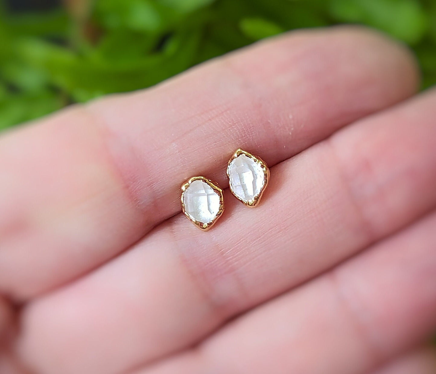 Herkimer diamond stud earrings in a hand, showcasing their raw elegance and unique design.