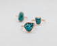 Natural turquoise rings with unique shapes and rose gold settings, showcasing vibrant aqua-blue hues.