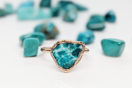 Natural Turquoise ring showcasing a unique aqua-blue stone, surrounded by turquoise gemstones on a white background.