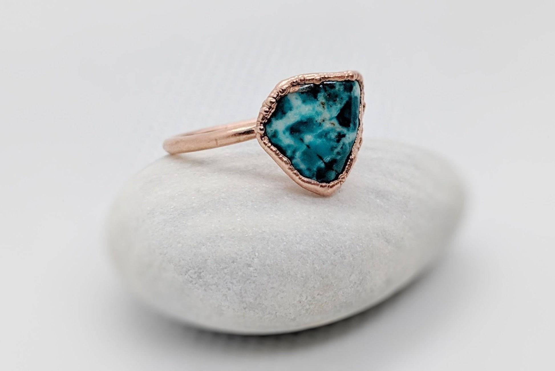 Natural turquoise ring on a smooth stone, featuring a uniquely shaped turquoise stone and rose gold band.