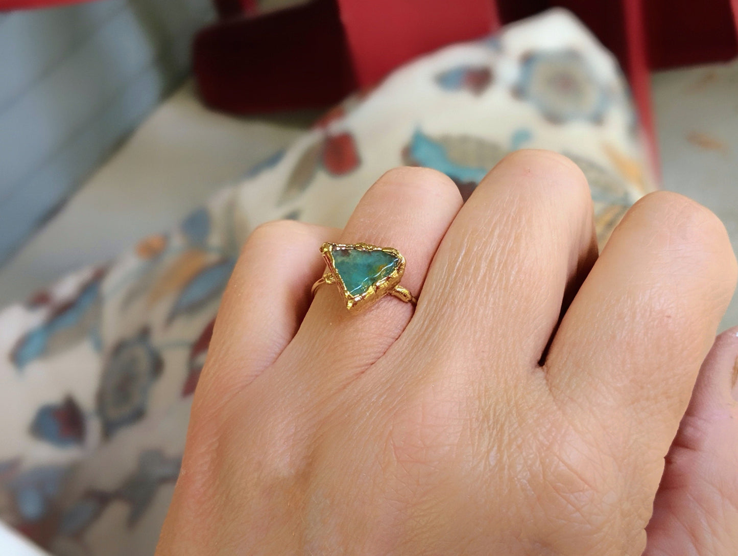 Handcrafted raw Peruvian opal ring in aqua blue, set on a 14k gold filled band worn on a hand.