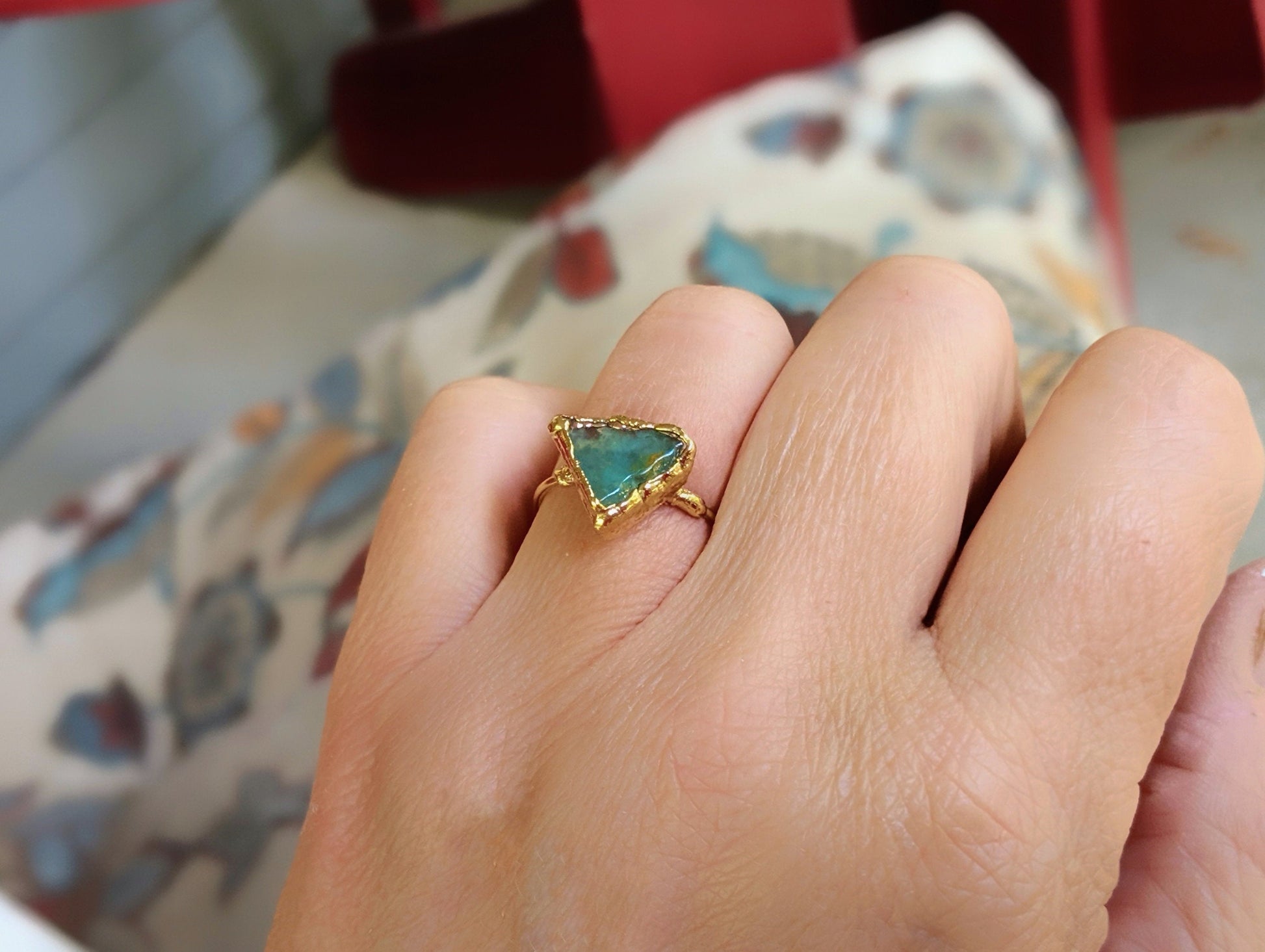Handcrafted raw Peruvian opal ring in aqua blue, set on a 14k gold filled band worn on a hand.