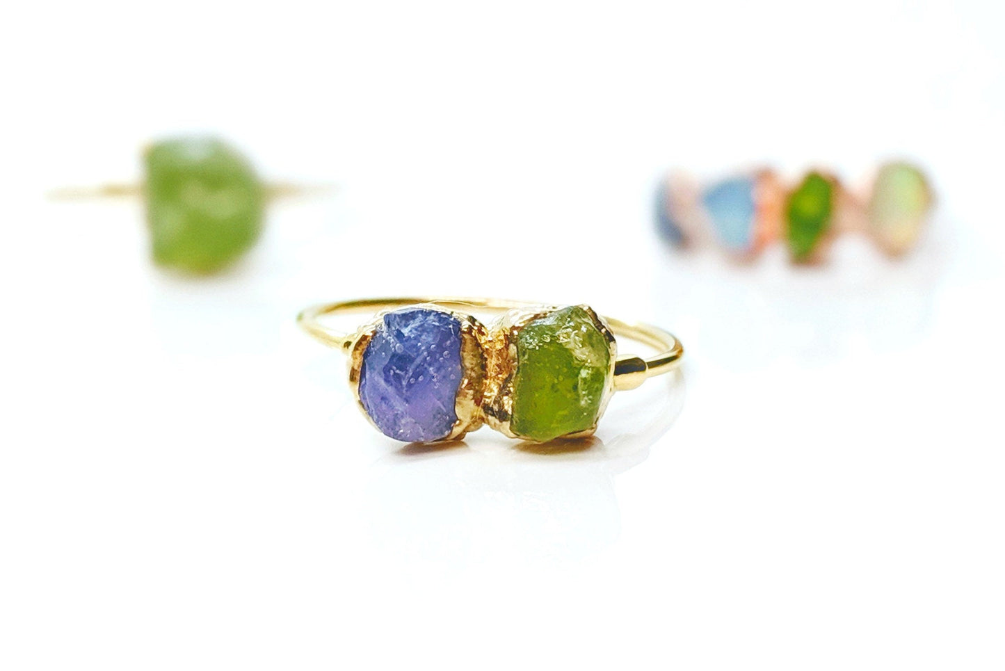 Handcrafted raw gemstone Mother's ring featuring purple and green stones on a gold band, a unique family birthstone heirloom.