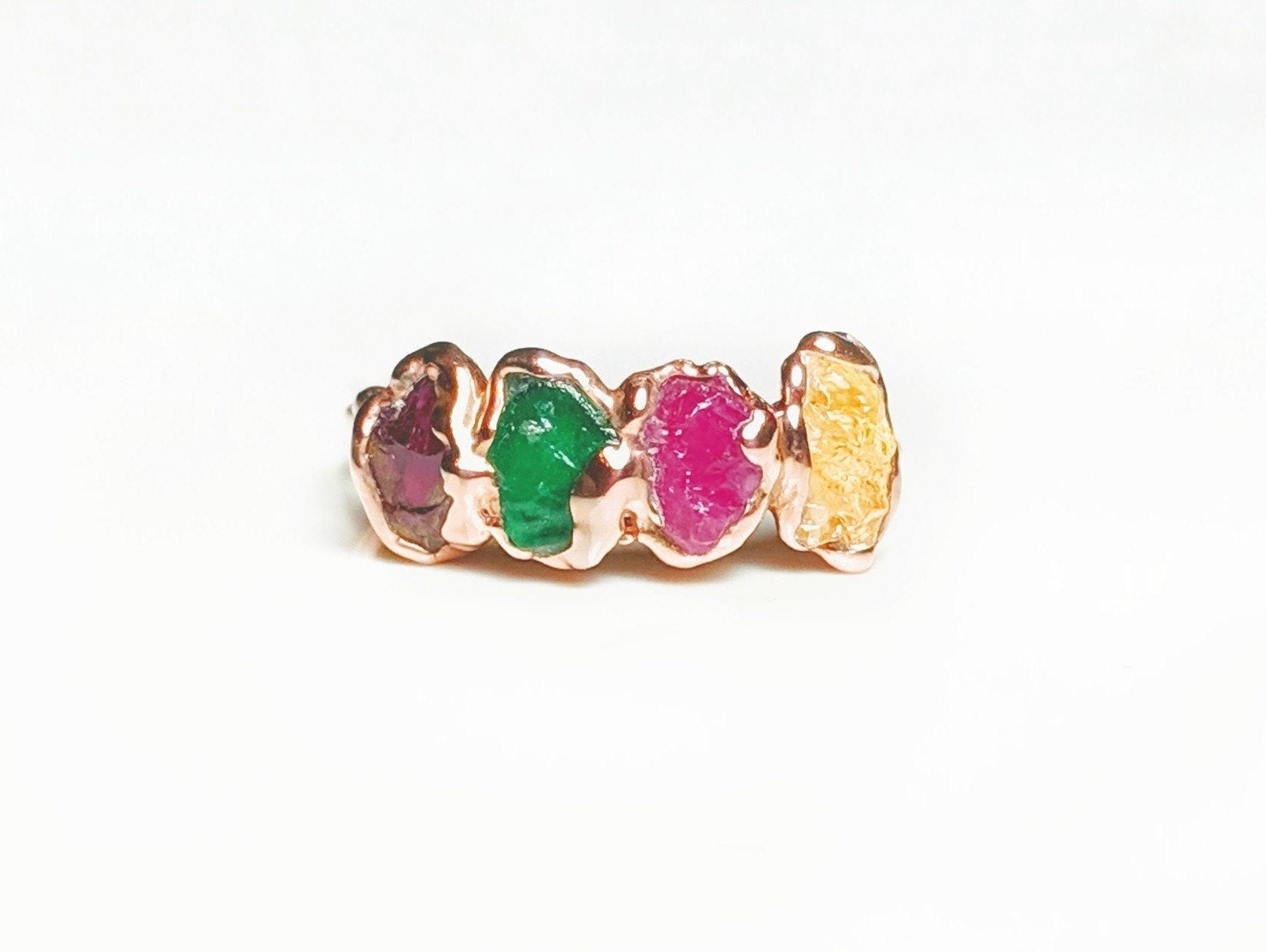Customized family birthstone ring with raw gemstones in various colors on a rose gold band.