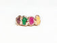 Customized family birthstone ring with raw gemstones in various colors on a rose gold band.