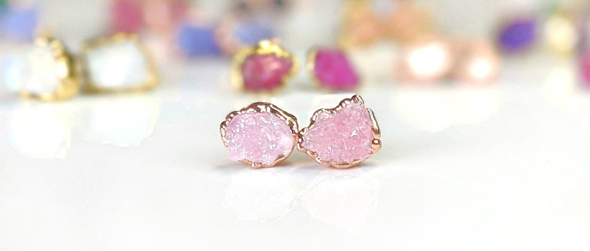 Raw Rose Quartz stud earrings set on rose gold, showcasing soft pink hues and natural crystal texture.