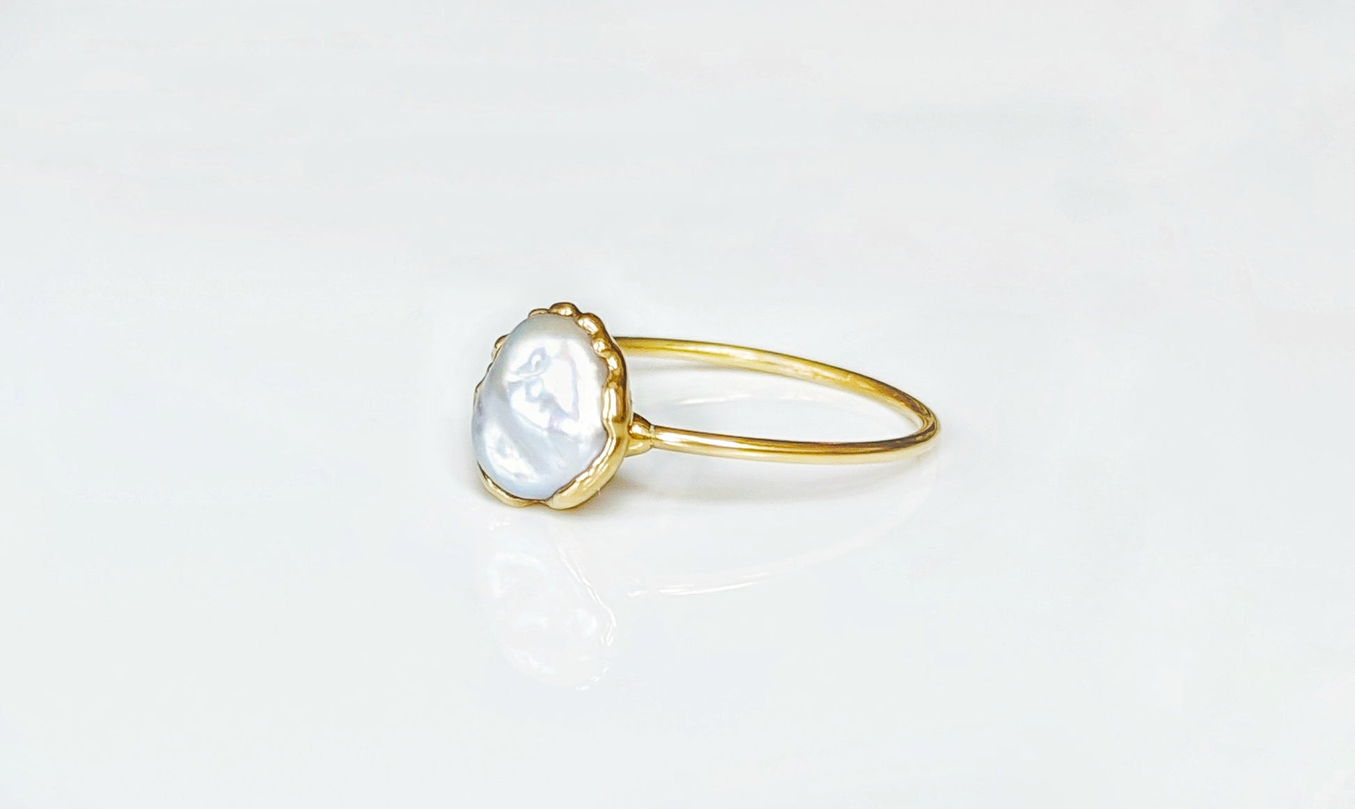 Small Freshwater Keshi pearl ring on a 14k Gold band showcasing subtle elegance and simplicity.